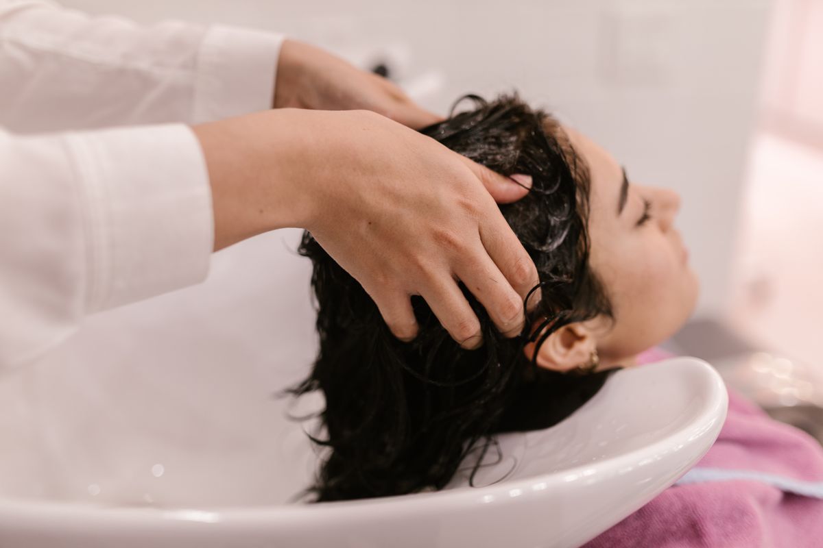 Lavado de cabeza y masaje capilar en un salón de peluquería